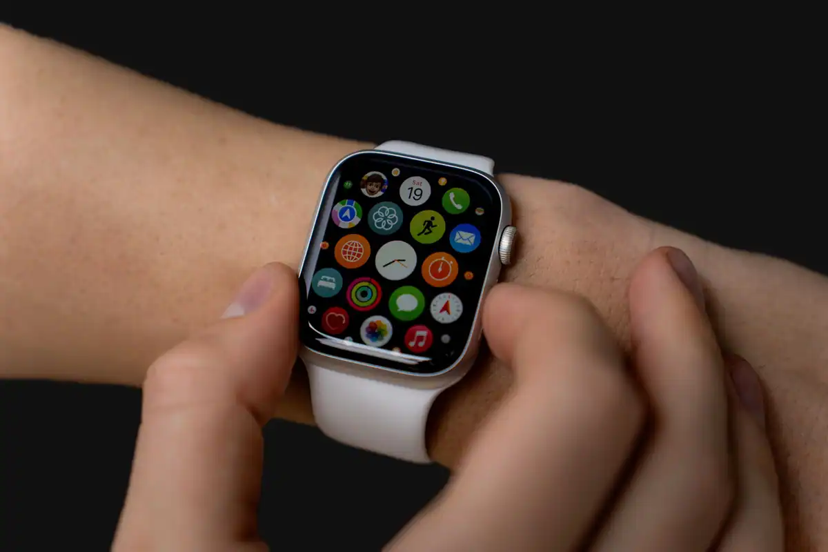 Persoană care își verifică smartwatch-ul cu ecran colorat, purtat la încheietura mâinii