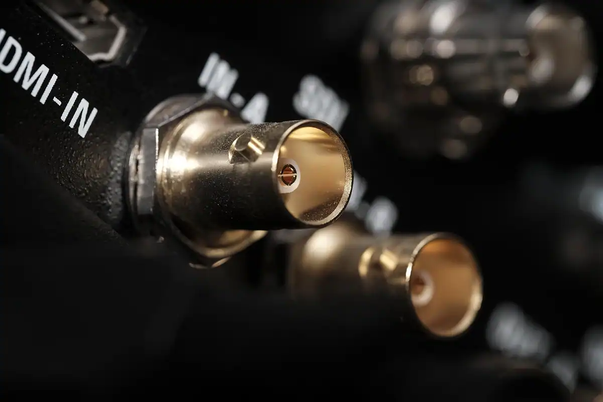 Cablu HDMI conectat la portul unui televizor, imagine de aproape cu mufa introdusă în conector