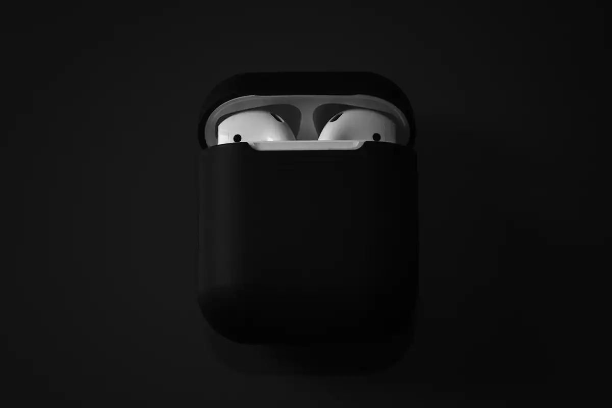 Căști wireless în carcasa de încărcare deschisă, pregătite pentru folosire cu telefonul