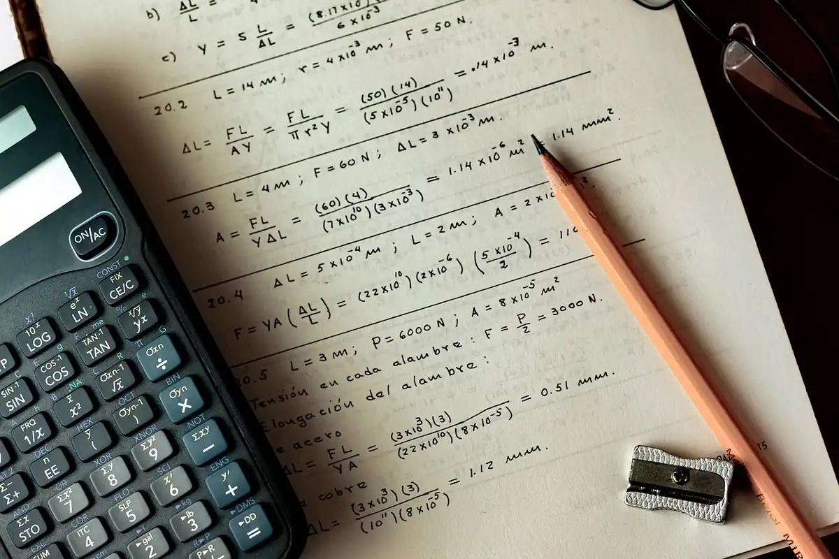Caiet cu calcule și calculator de birou, folosite pentru estimarea numărului de încărcări