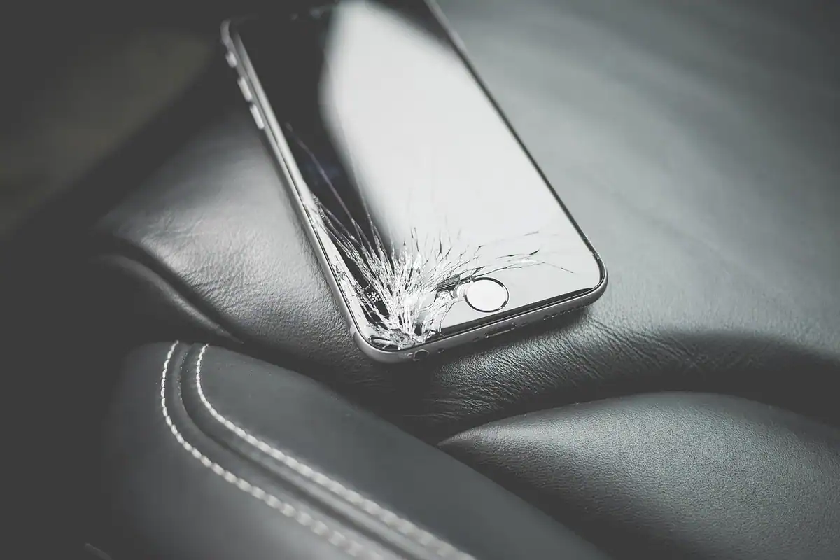 Ecran de smartphone crăpat, văzut de aproape, cu fisuri vizibile în sticla afișajului