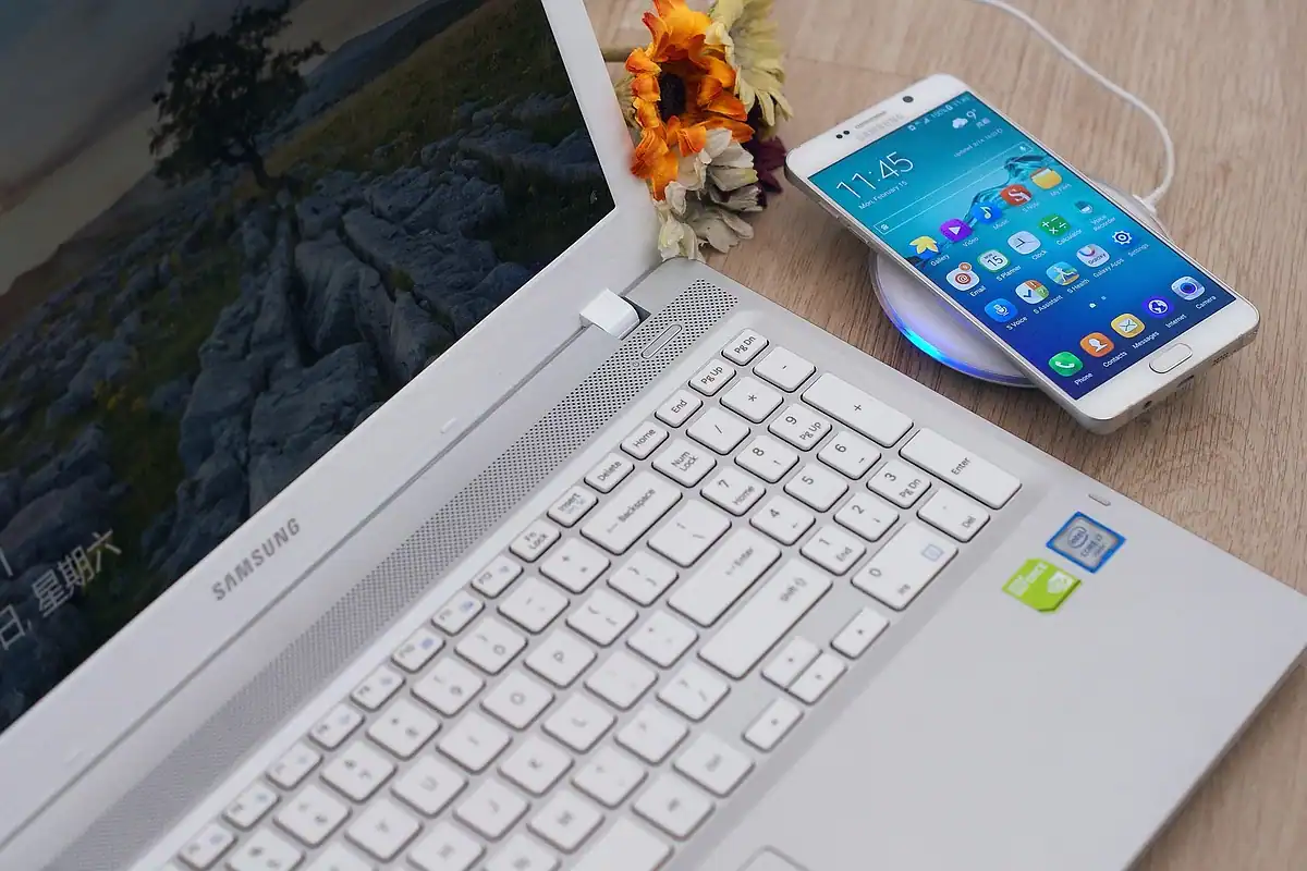Birou cu laptop, telefon și încărcător conectate, pentru alimentarea mai multor dispozitive