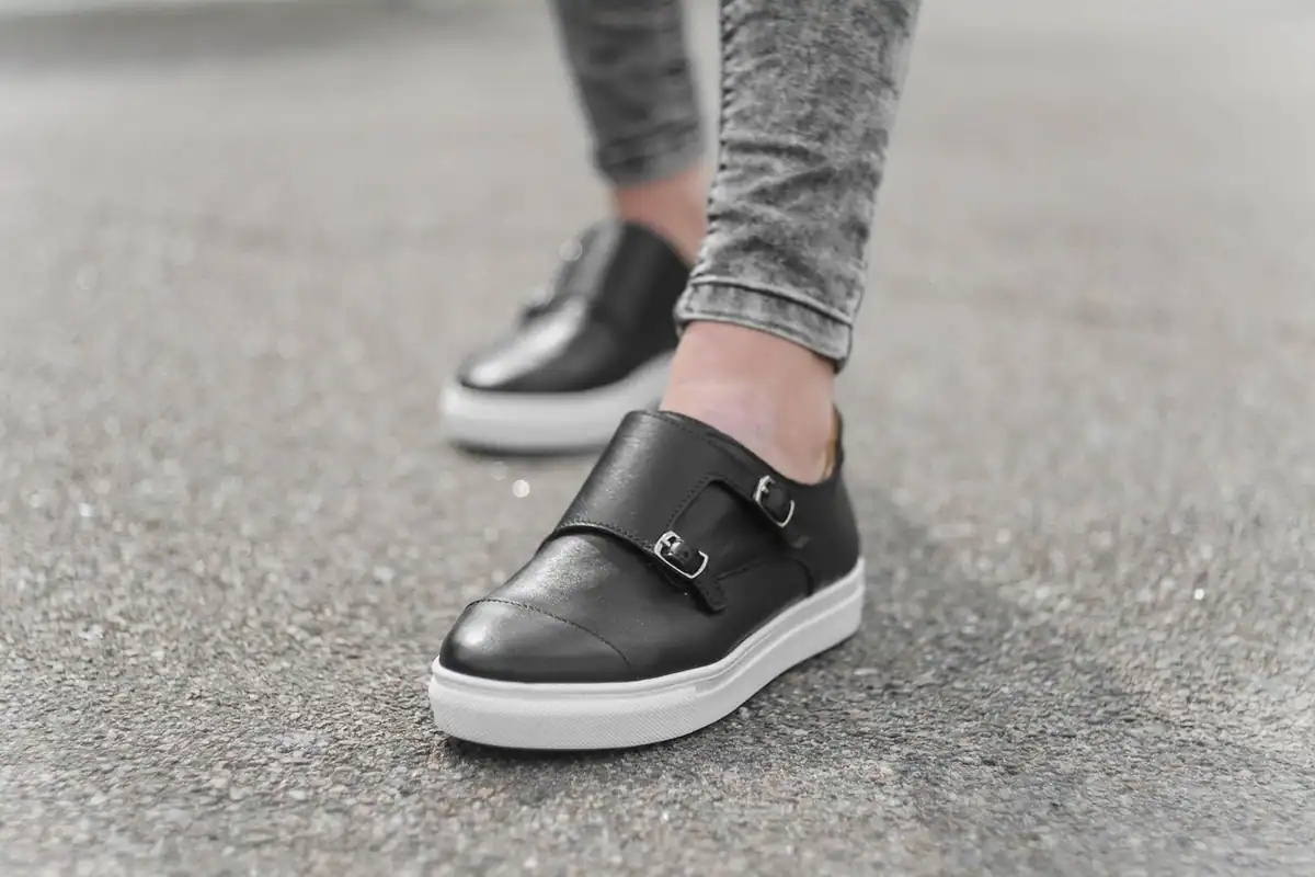 Pantofi sport de mers pe jos pe trotuarul unui oraș, în timpul unei plimbări de zi cu zi