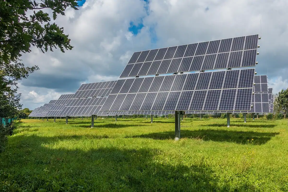 Panou solar pliabil întins pe iarbă, orientat spre soare pentru încărcarea dispozitivelor