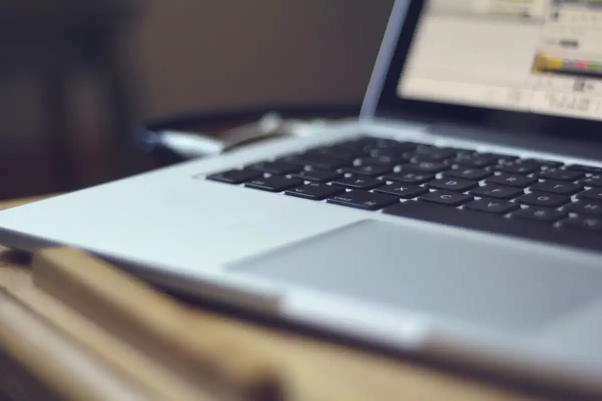 Suport de laptop din aluminiu pe un birou, cu laptopul ridicat la înălțimea ochilor
