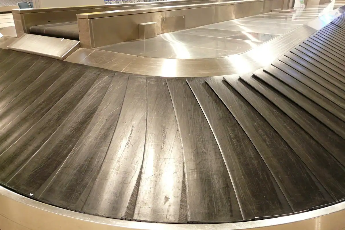 Bandă rulantă metalică pentru bagaje, într-un aeroport, fără valize pe ea